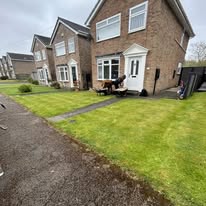 Before 3 Two suburban houses with tidy gardens and a pathway, under a cloudy sky.