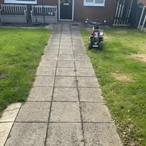 Before 4 Pathway leading to a house with a small vehicle parked on the grass.